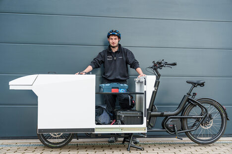 Handwerker mit beladenem Lastenrad