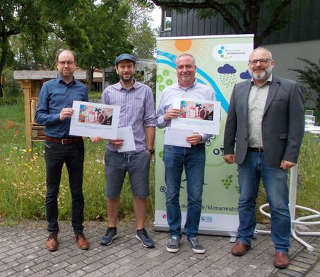 Christian Hoffmann (links), Leiter Abteilung Kunde & Öffentlichkeit der Mainzer Mobilität und Olaf Nehrbaß (rechts), Amtsleiter Grün- und Umweltamt, übergeben die beiden Hauptgewinne im Fotowettbewerb Klimaschutz und Klimawandel an den Erstplatzierten Andreas Thoma (zweiter  v. l.) und den Zweitplatzierten Jens Wolf Sager (dritter v.l.).